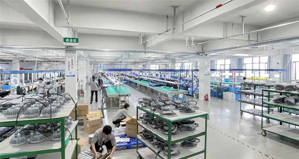 Workers and industrial luminaires in the TORMIN assembly and packing workshop.